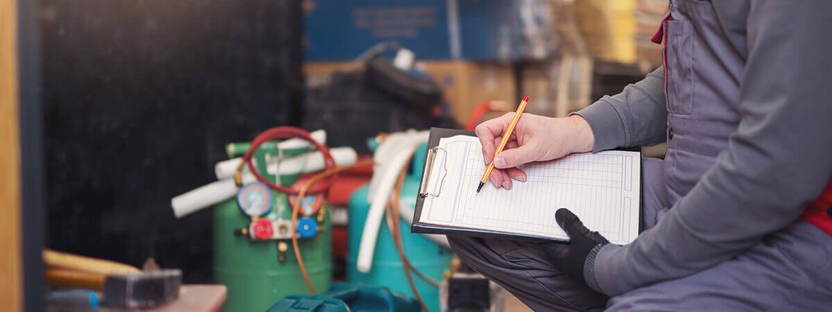 工具を広げて記録を取る、フロン回収の作業風景